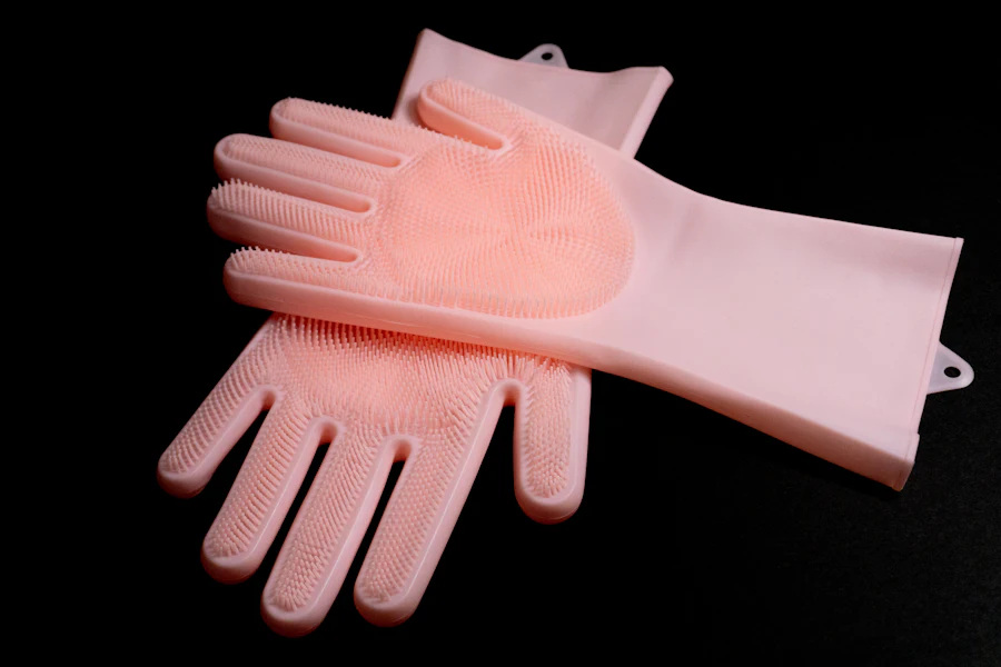 A pair of pink rubber gloves on a black background