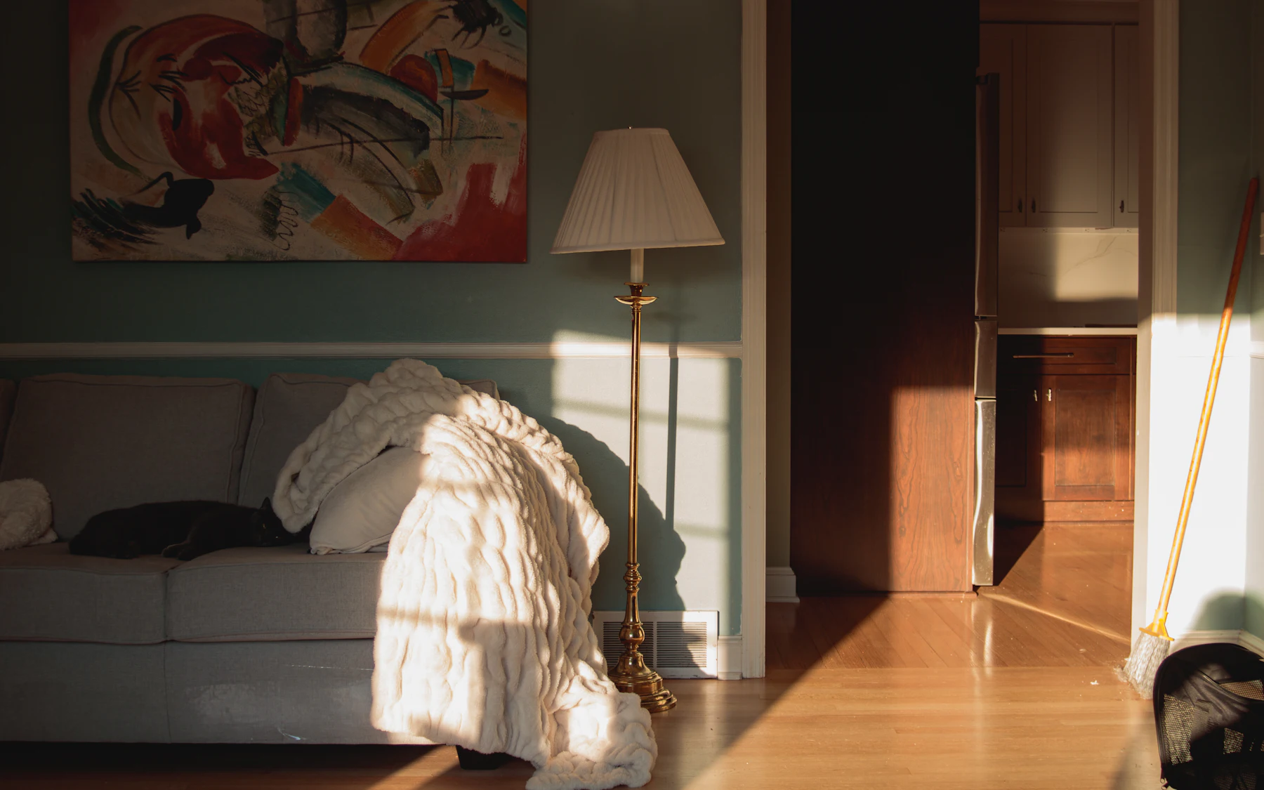 A tidy lounge with a cream sofa in late afternoon sun